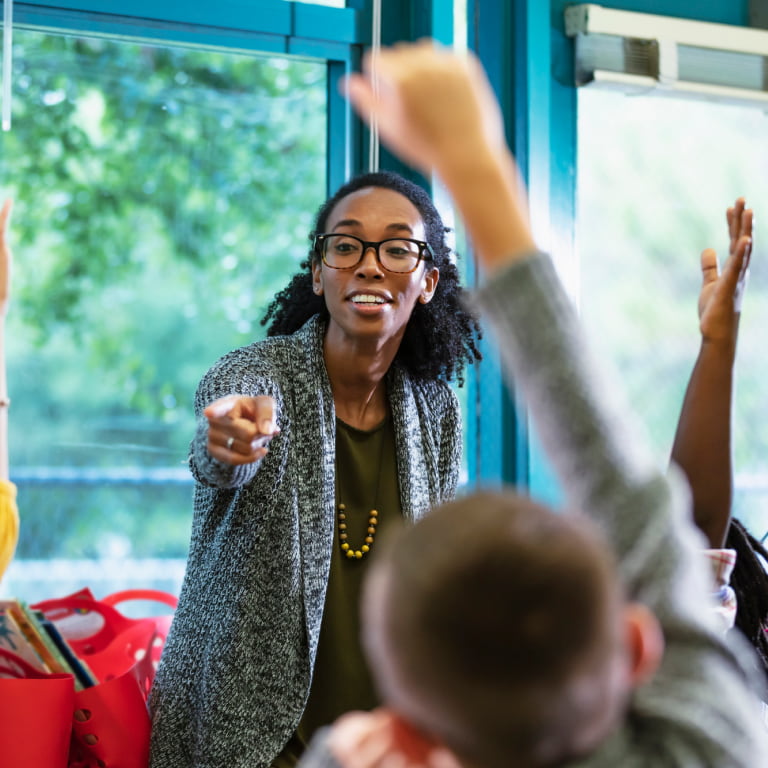 Female African American teacher pointing to grade school student