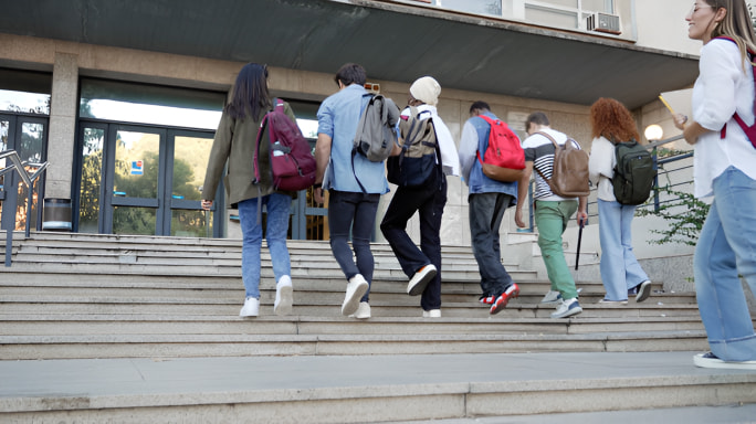 Students walking up steps into school at start of day